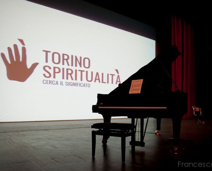 Un pianoforte di fronte alla scritta di Torino Spiritualità