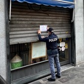 Poliziotto che affigge un cartello di chiusura