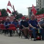 persone sedute con bandiere Cgil