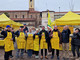 persone vestite di giallo in gruppo davanti a un gazebo