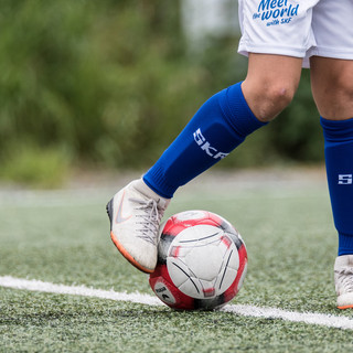 Gambe di un calciatore che toccano un pallone