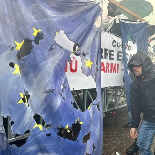 Primo Maggio, a Torino bruciate le bandiere della Nato e dell’Europa. Il fantoccio di Meloni sfila con il braccio teso [FOTO E VIDEO]