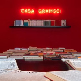 casa gramsci con scritta rossa luminosa e libri