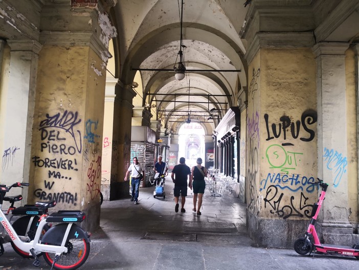 Tra graffiti, vandali e vetrine vuote, il degrado dei portici di corso Vittorio [FOTO]