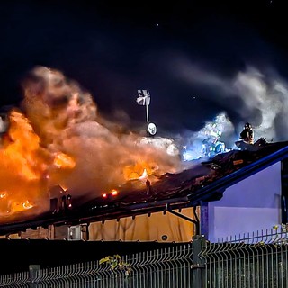 incendio di un tetto e vigili del fuoco in azione