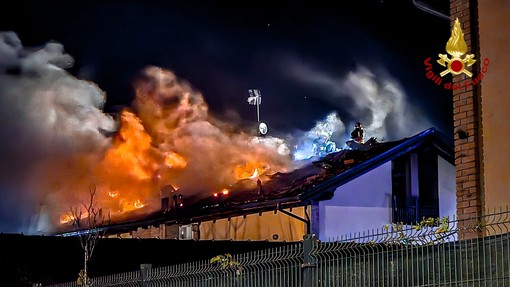 incendio di un tetto e vigili del fuoco in azione