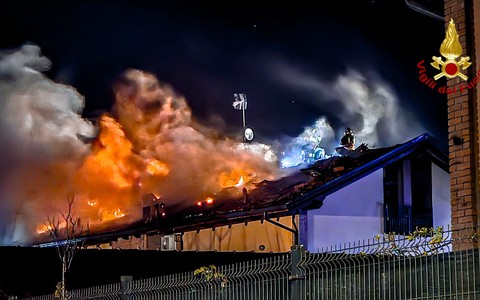 incendio di un tetto e vigili del fuoco in azione