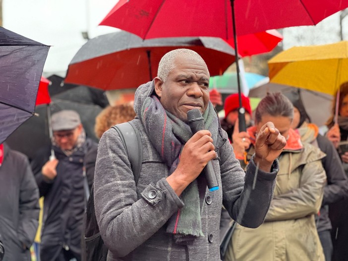 manifestazione di protesta con ombrelli e persone in piedi