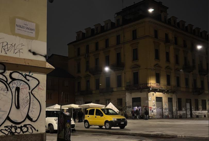 piazza di notte con nome riscritto e fontanella pubblica