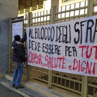 Persona che appende uno striscione sugli sfratti